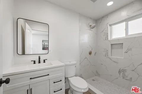 a bathroom with a sink a toilet and shower