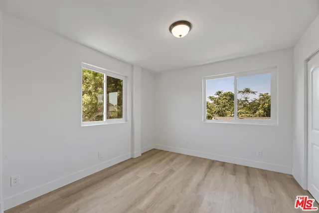 an empty room with a window and a ceiling fan