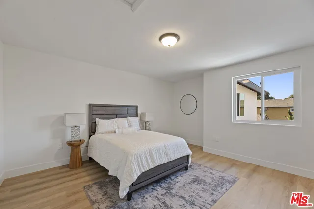 a bedroom with a bed and painting on the wall