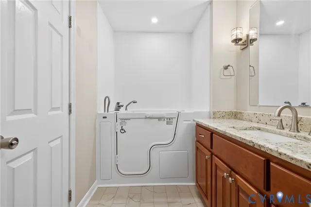 a bathroom with a granite countertop sink a mirror and a shower