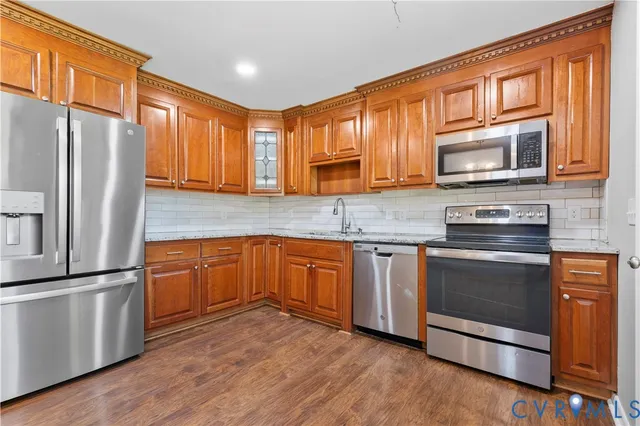 a kitchen with stainless steel appliances granite countertop a refrigerator stove top oven and sink