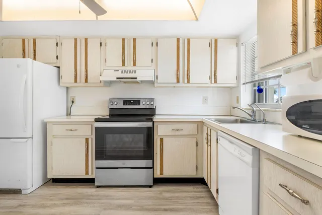 a kitchen with granite countertop white cabinets and white appliances