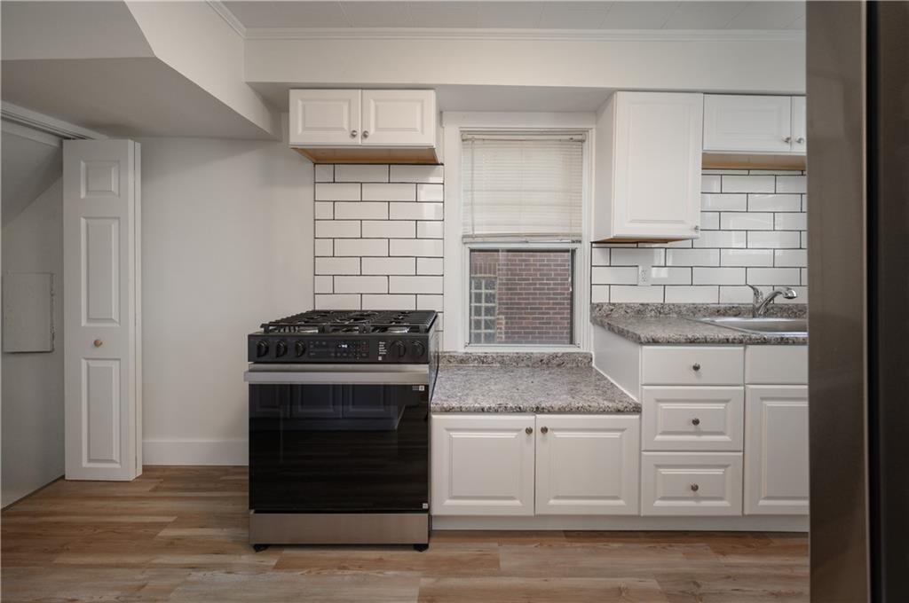 2606 Belmar Place Pittsburgh, PA 15218 - Photo 11 of 27 a kitchen with granite countertop white cabinets and a stove