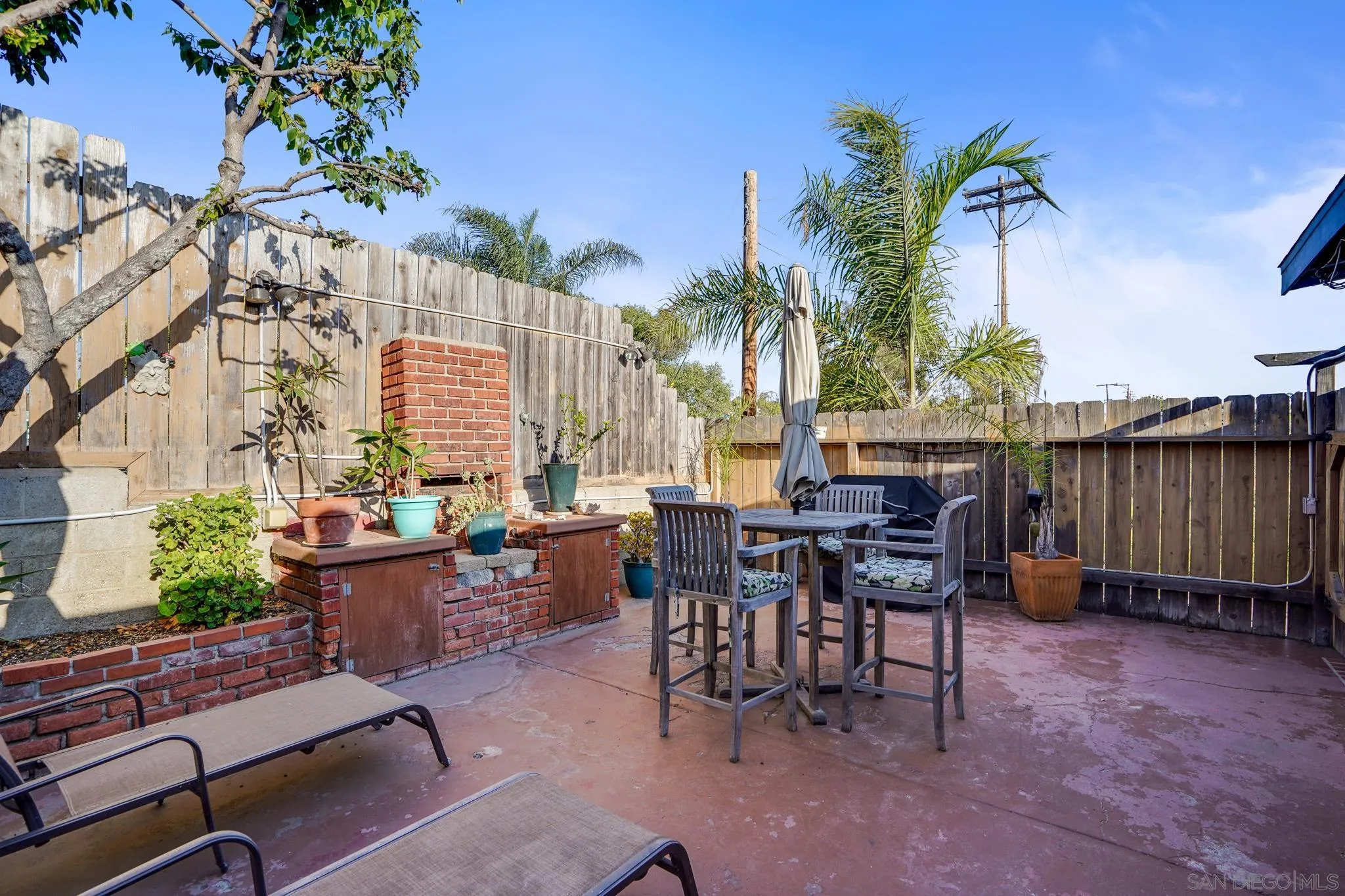 253 B Street Encinitas, CA 92024 - Photo 49 of 61 a view of a patio with table and chairs potted plants and palm tree