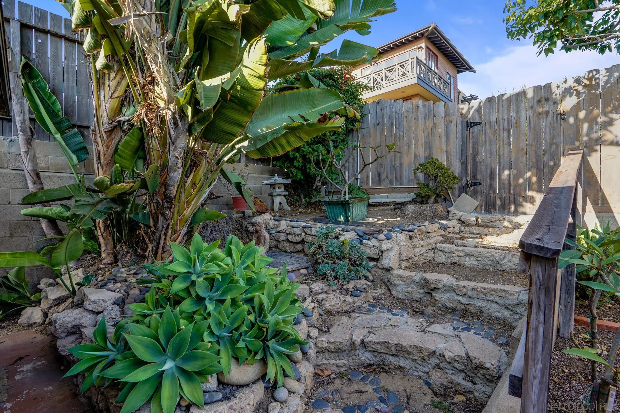 253 B Street Encinitas, CA 92024 - Photo 52 of 61 a backyard of a house with lots of plants and wooden fence