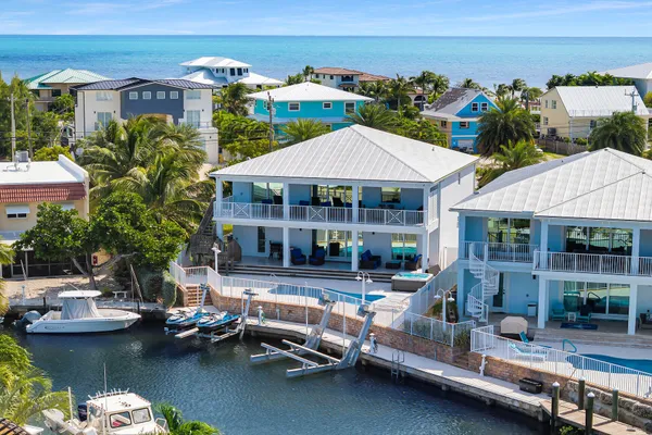 an aerial view of ocean and residential houses with outdoor space
