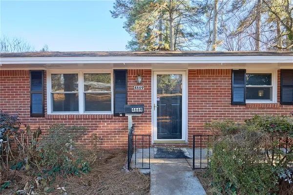 front view of a brick house with a small yard