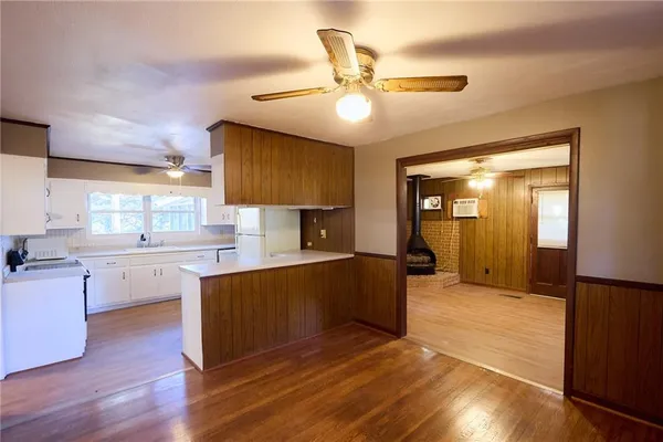 a kitchen with granite countertop a stove cabinets and wooden floor