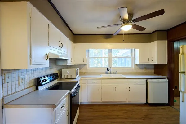 a kitchen with stainless steel appliances granite countertop a sink a stove and a refrigerator