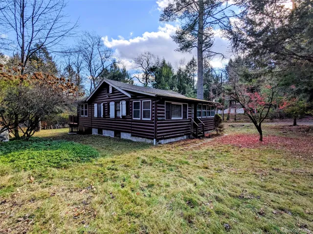 a view of a house with a yard and sitting area