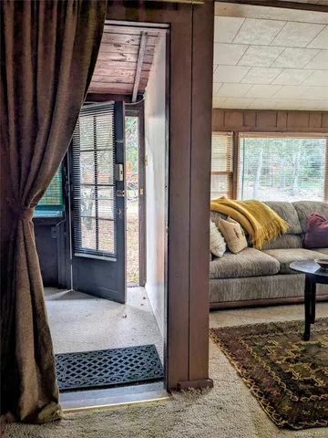 a room with a table chairs and a large window