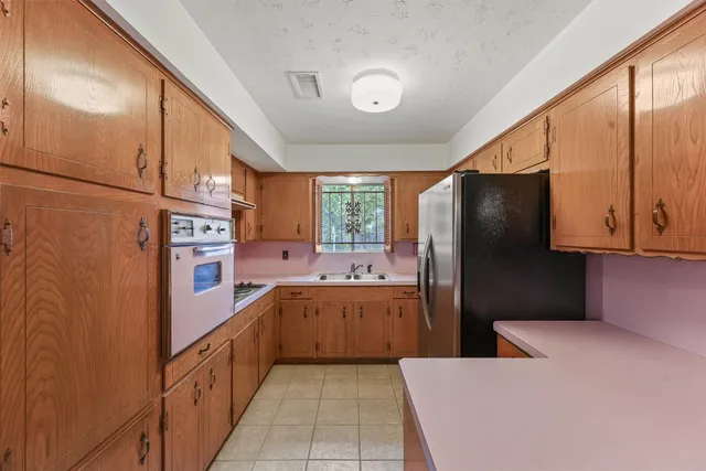 a kitchen with a refrigerator sink and cabinets