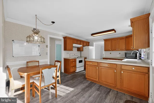 a large kitchen with cabinets wooden floor and stainless steel appliances