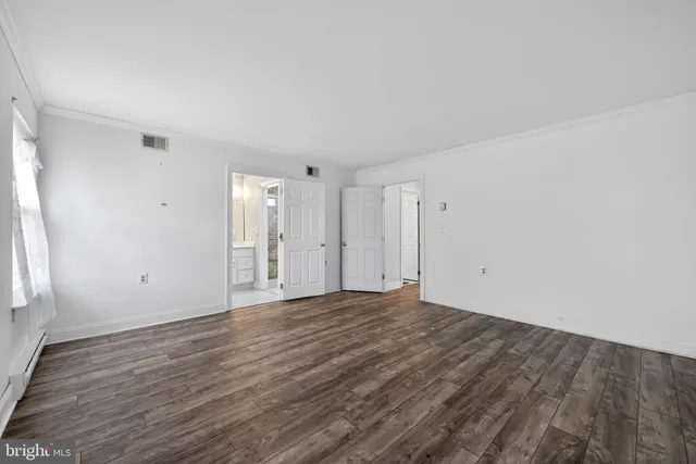 a view of an empty room with wooden floor
