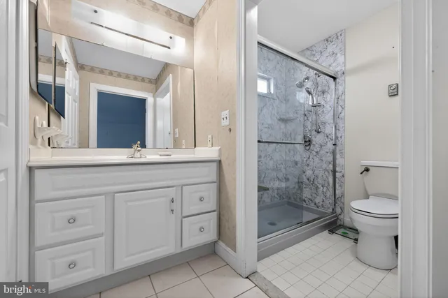 a bathroom with a shower toilet sink and double vanity
