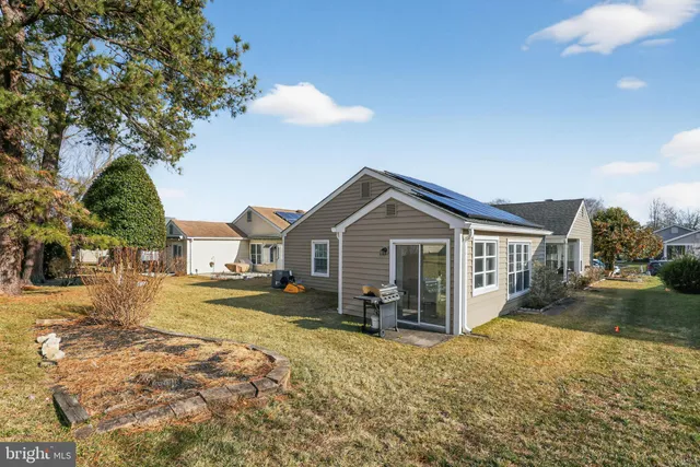 a view of a yard in front of a house with wooden fence