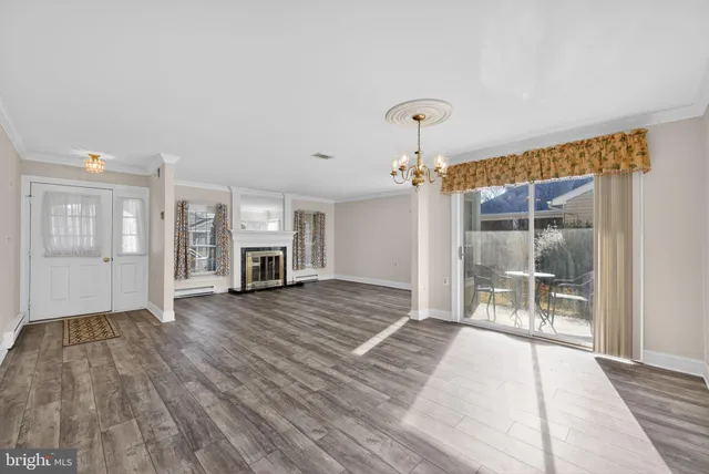 a view of empty room with wooden floor and fireplace