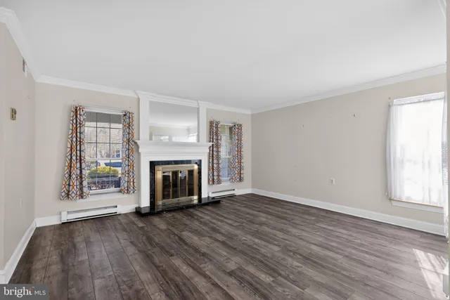 wooden floor fireplace and windows in an empty room
