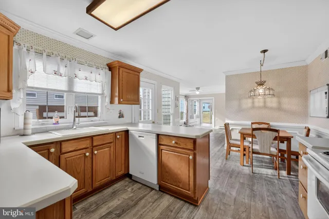 a large kitchen with cabinets chairs and wooden floor
