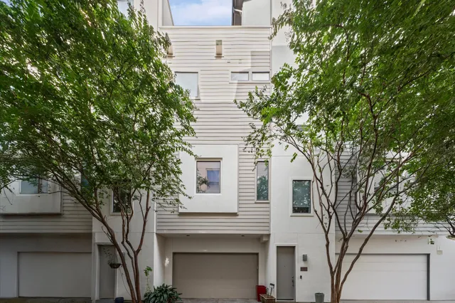 a white house that has a tree in front of it