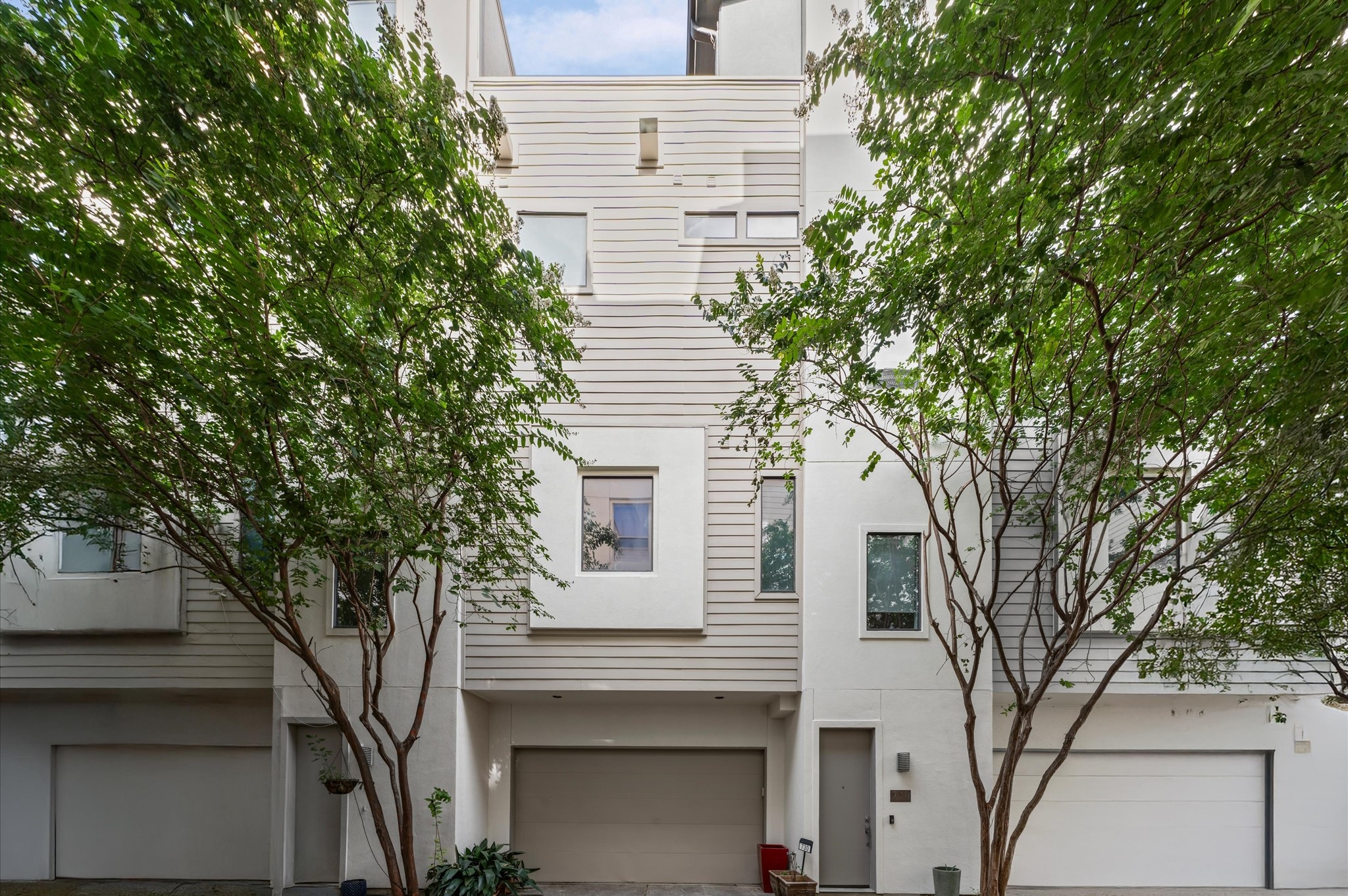 a white house that has a tree in front of it