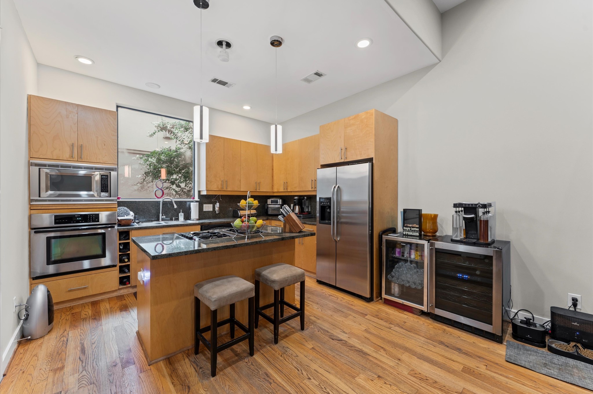 730 Ruthven Street Houston, TX 77019 - Photo 6 of 36 a kitchen with wooden cabinets and stainless steel appliances