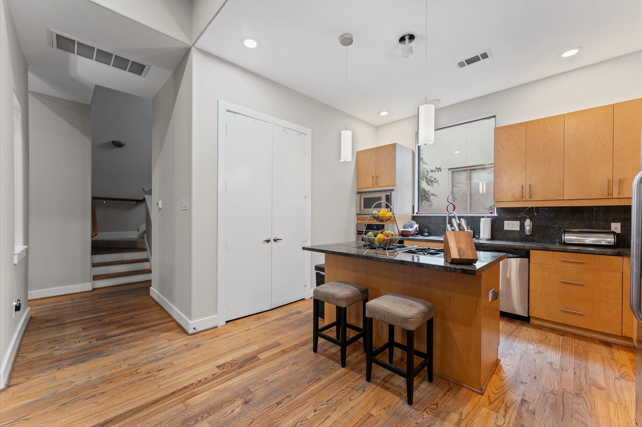 730 Ruthven Street Houston, TX 77019 - Photo 8 of 36 a kitchen with stainless steel appliances granite countertop a table chairs sink and cabinets