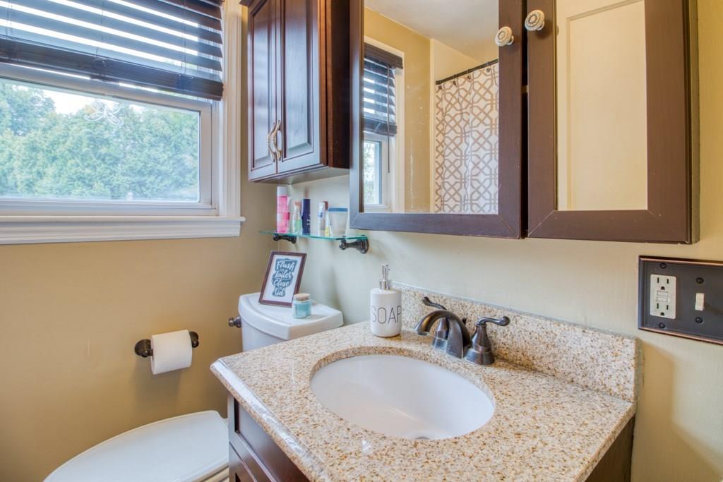 129 Amostown Road West Springfield, MA 01089 - Photo 9 of 25 a bathroom with a granite countertop sink a mirror and a toilet