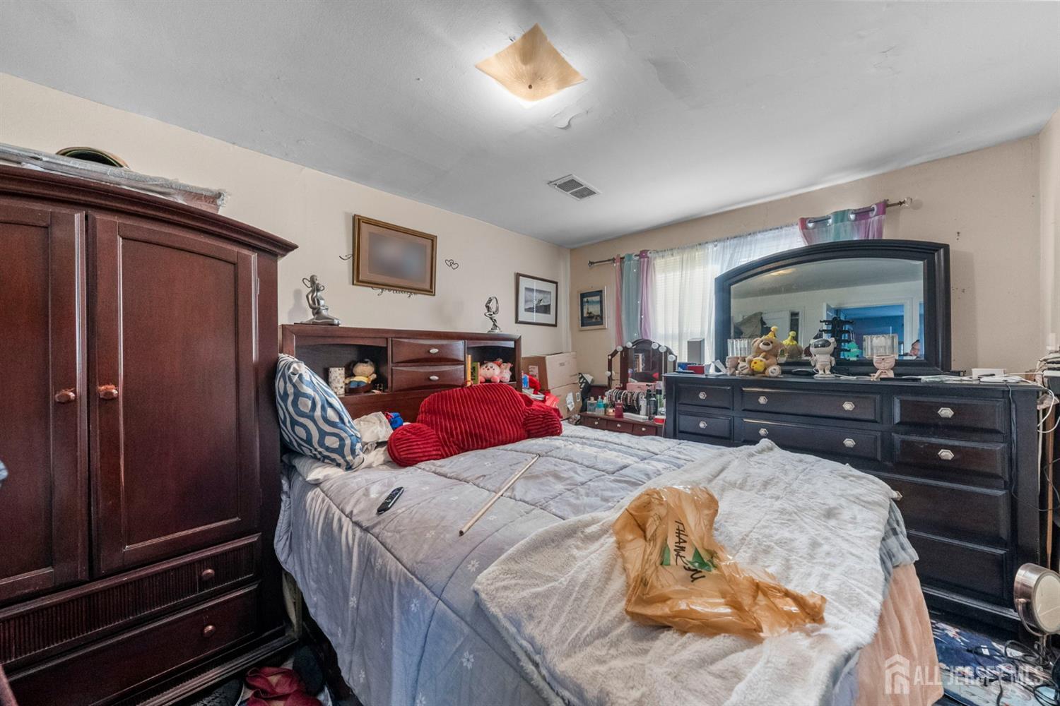 973 Ellis Parkway Edison, NJ 08820 - Photo 17 of 34 a bed room with a bed and a mirror
