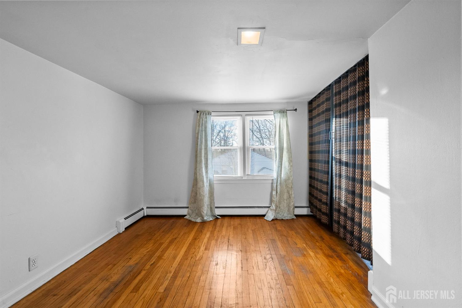 973 Ellis Parkway Edison, NJ 08820 - Photo 25 of 34 an empty room with wooden floor and windows