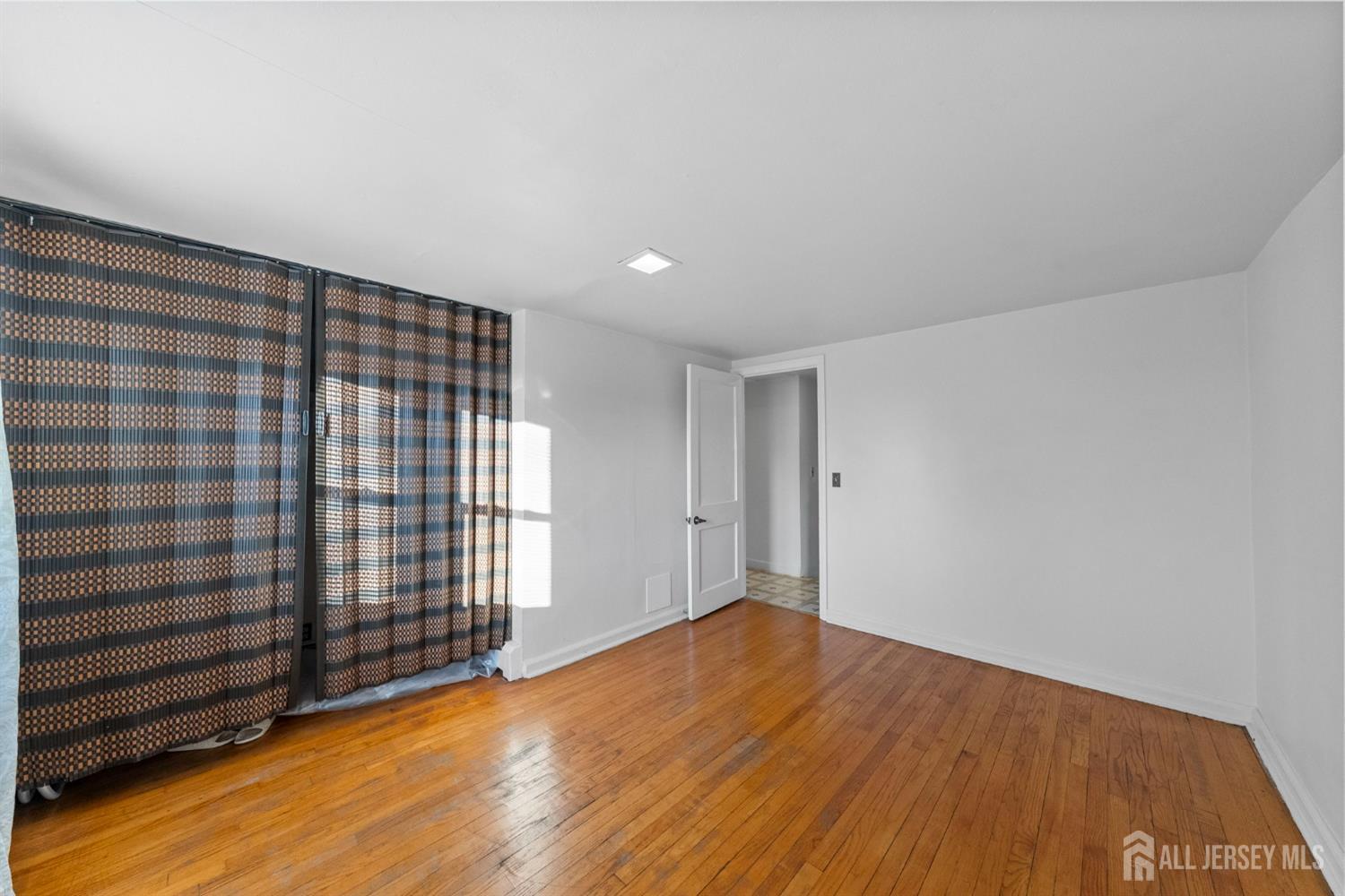 973 Ellis Parkway Edison, NJ 08820 - Photo 27 of 34 a view of an empty room with wooden floor and a window