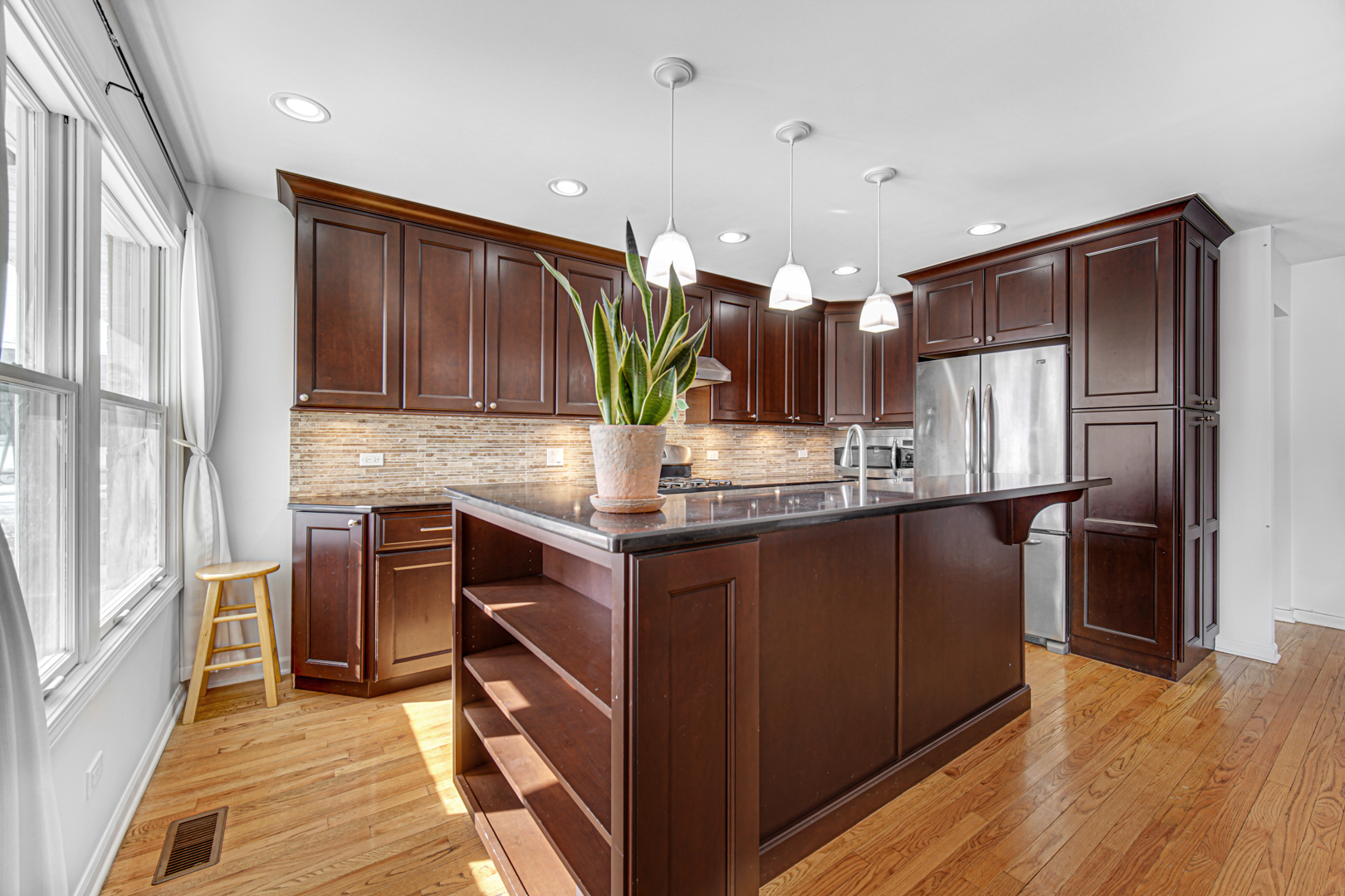 1855 North Happ Road Northbrook, IL 60062 - Photo 8 of 32 a kitchen with kitchen island granite countertop wooden cabinets a refrigerator and a sink