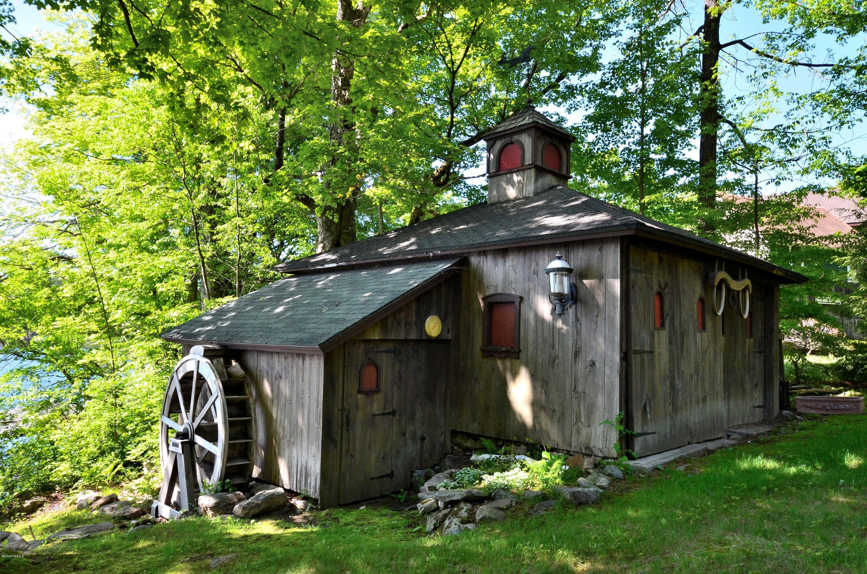 996 Reservoir Road Otis, MA 01029 - Photo 20 of 23 a view of a wooden house with a yard and plants