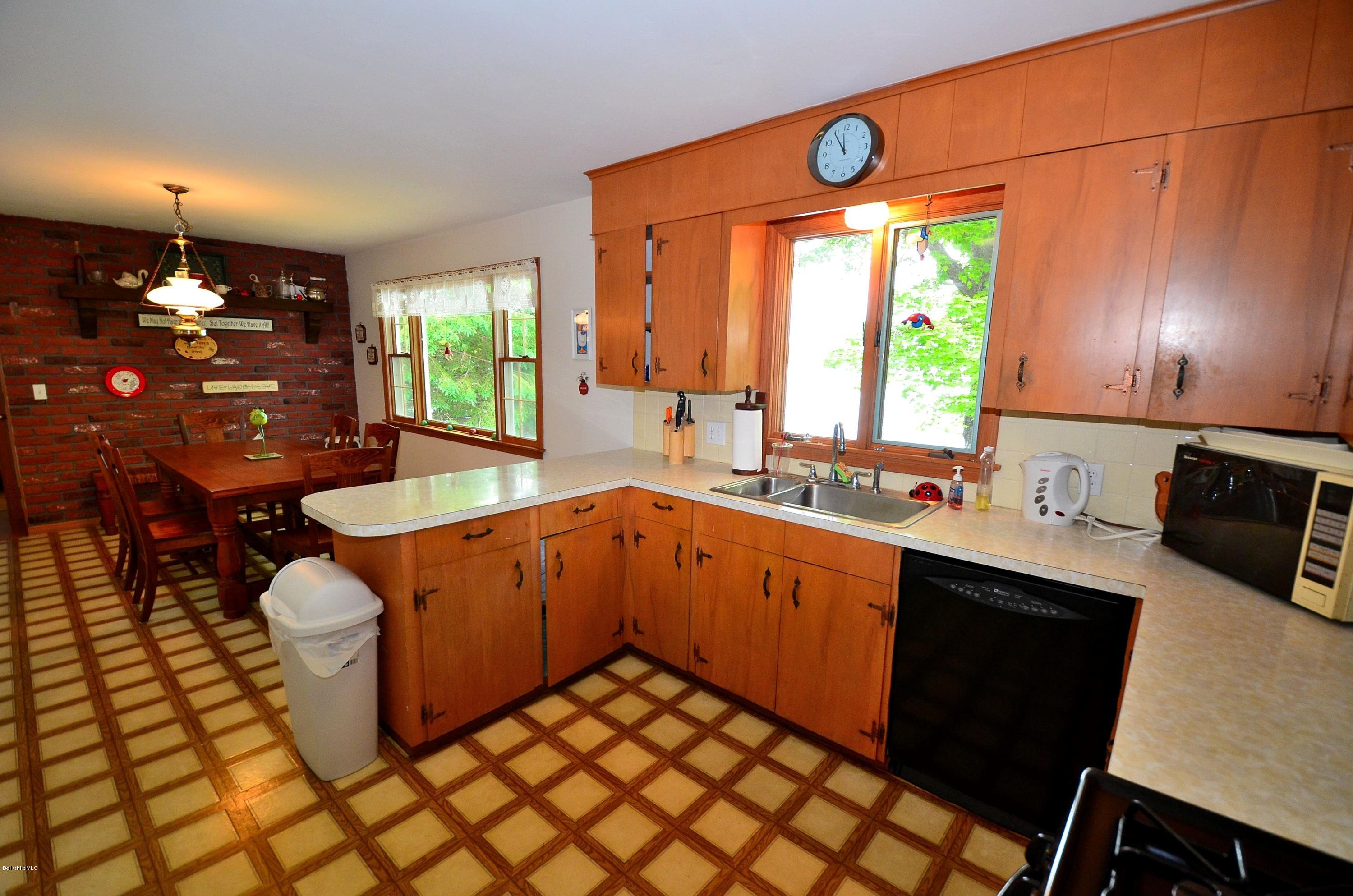 996 Reservoir Road Otis, MA 01029 - Photo 8 of 23 a large kitchen with granite countertop a sink a stove a dining table and chairs