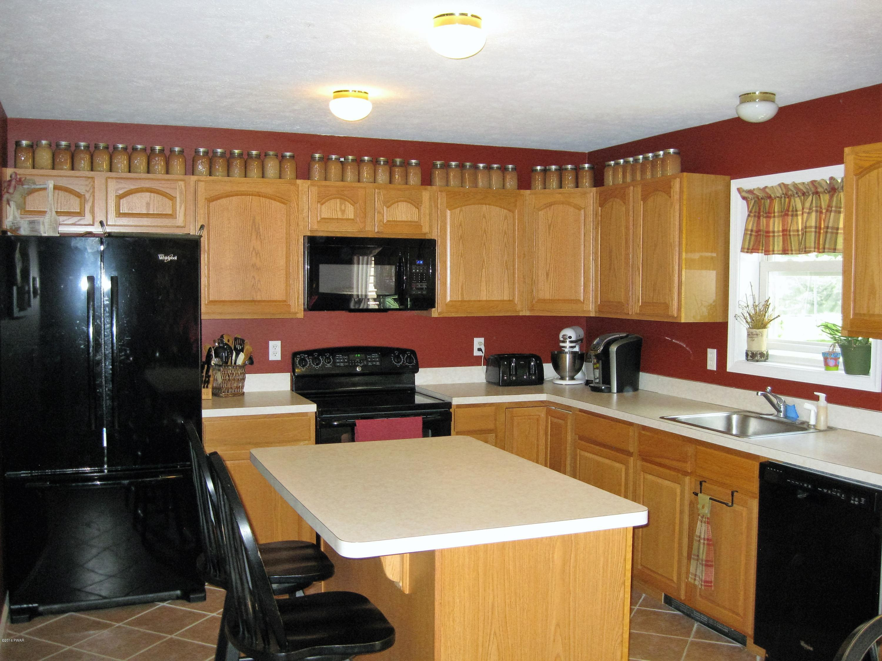 137 Caribou Road Dingmans Ferry, PA 18328 - Photo 12 of 34 a kitchen with a sink a stove and chairs