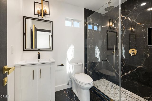 a bathroom with a toilet a sink a shower and mirror