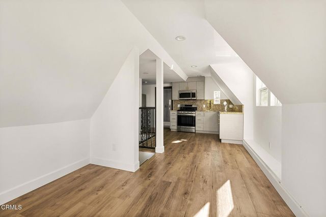 a kitchen with granite countertop a refrigerator and a stove top oven