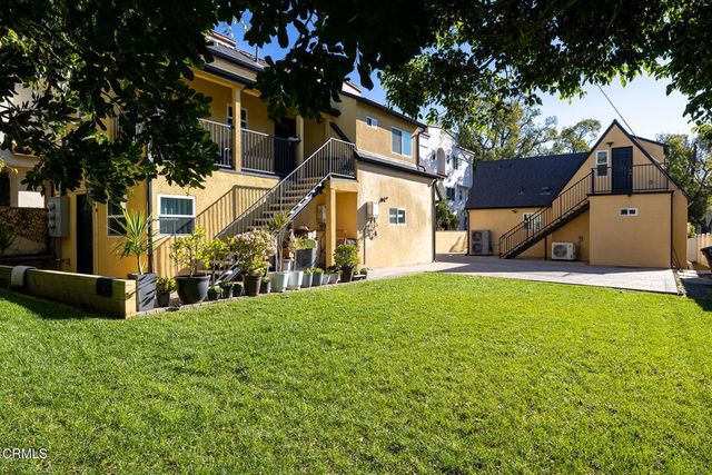 a view of a backyard with table and chairs and a barbeque with wooden fence