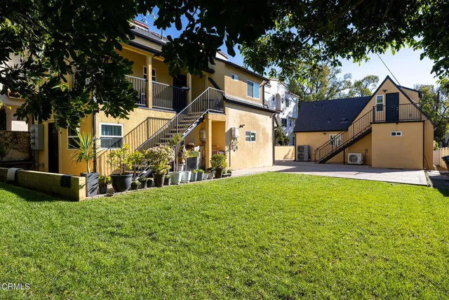 a view of a backyard with table and chairs and a barbeque with wooden fence
