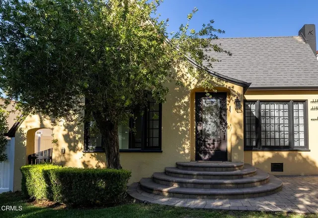 a front view of a house with a garden