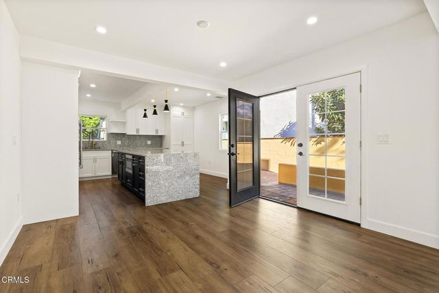 a view of a kitchen with furniture and wooden floor
