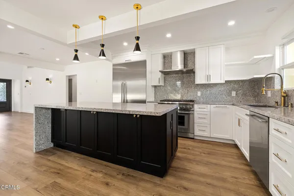 a kitchen with kitchen island granite countertop wooden cabinets and white appliances