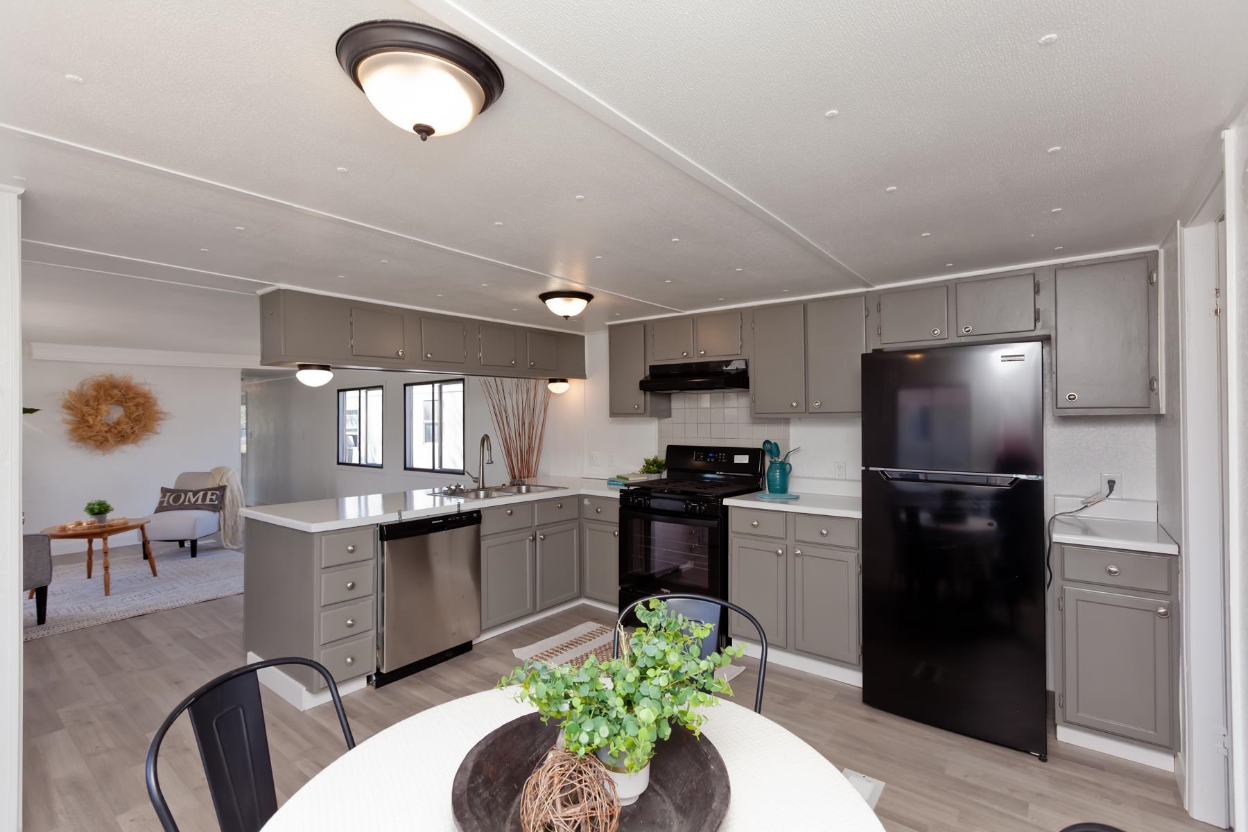432 Pisces Circle Fruita, CO 81521 - Photo 13 of 40 a kitchen with stainless steel appliances granite countertop a refrigerator a stove a sink a dining table and chairs with wooden floor