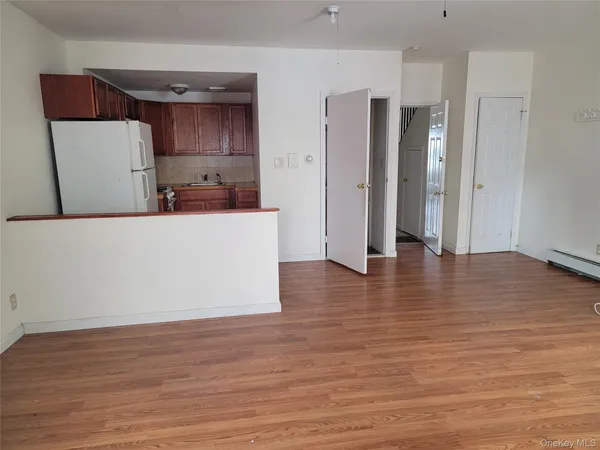 a view of a kitchen with wooden floor and a refrigerator