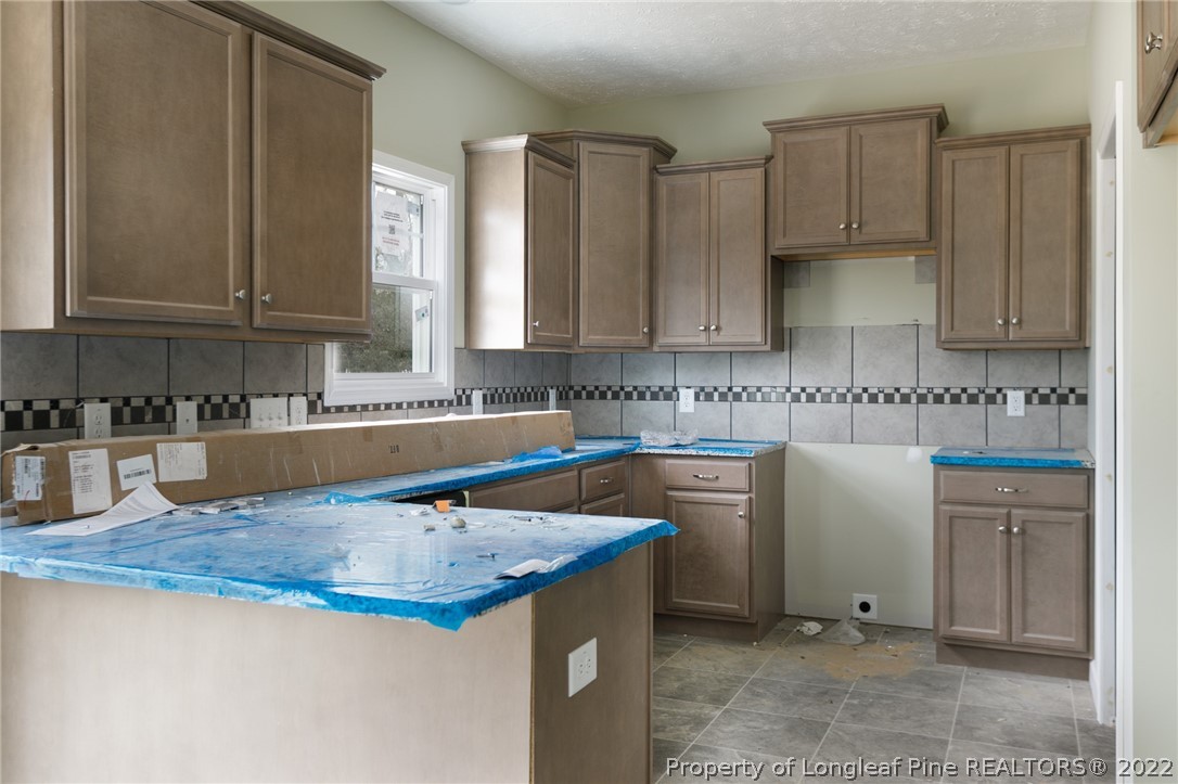 5512 Tolarsville Road St. Pauls, NC 28384 - Photo 3 of 5 a kitchen with granite countertop a sink a stove and cabinets