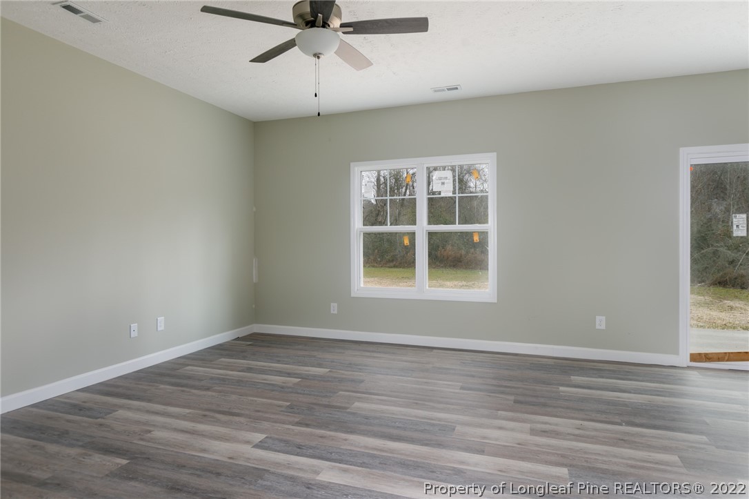 5512 Tolarsville Road St. Pauls, NC 28384 - Photo 4 of 5 a view of an empty room with wooden floor and a window