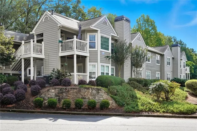 a front view of a house with a yard and potted plants