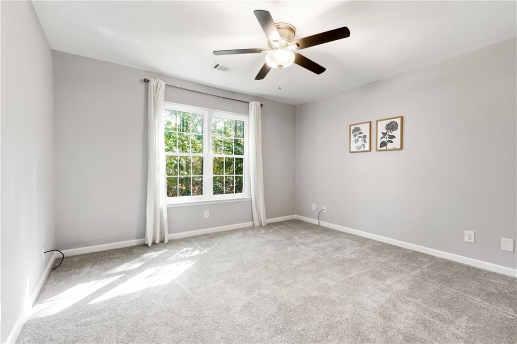 604 Mill Pond Road, Unit 604 Roswell, GA 30076 - Photo 12 of 28 an empty room with a ceiling fan and window