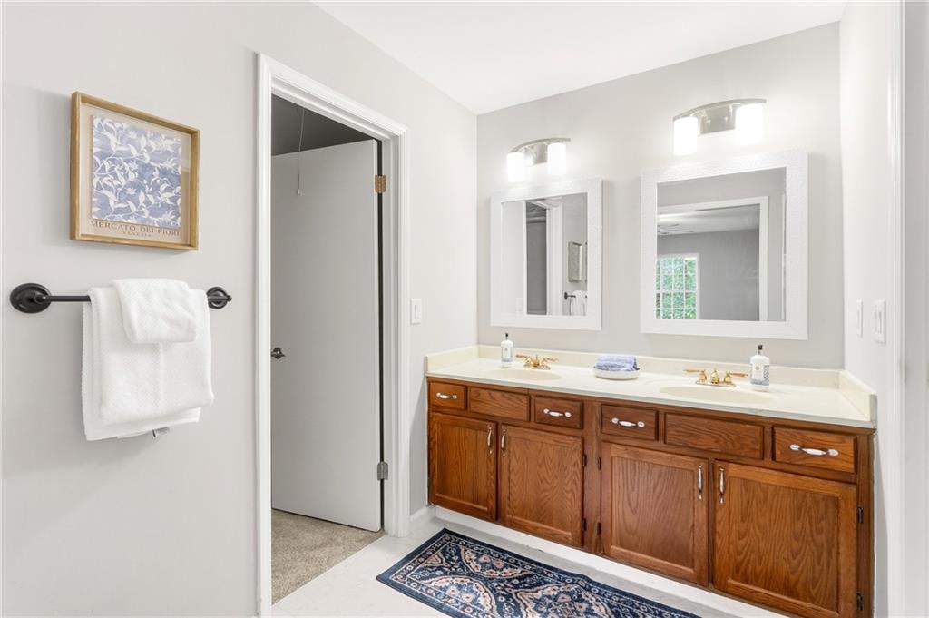 604 Mill Pond Road, Unit 604 Roswell, GA 30076 - Photo 18 of 28 a bathroom with a double vanity sink a mirror and a shower