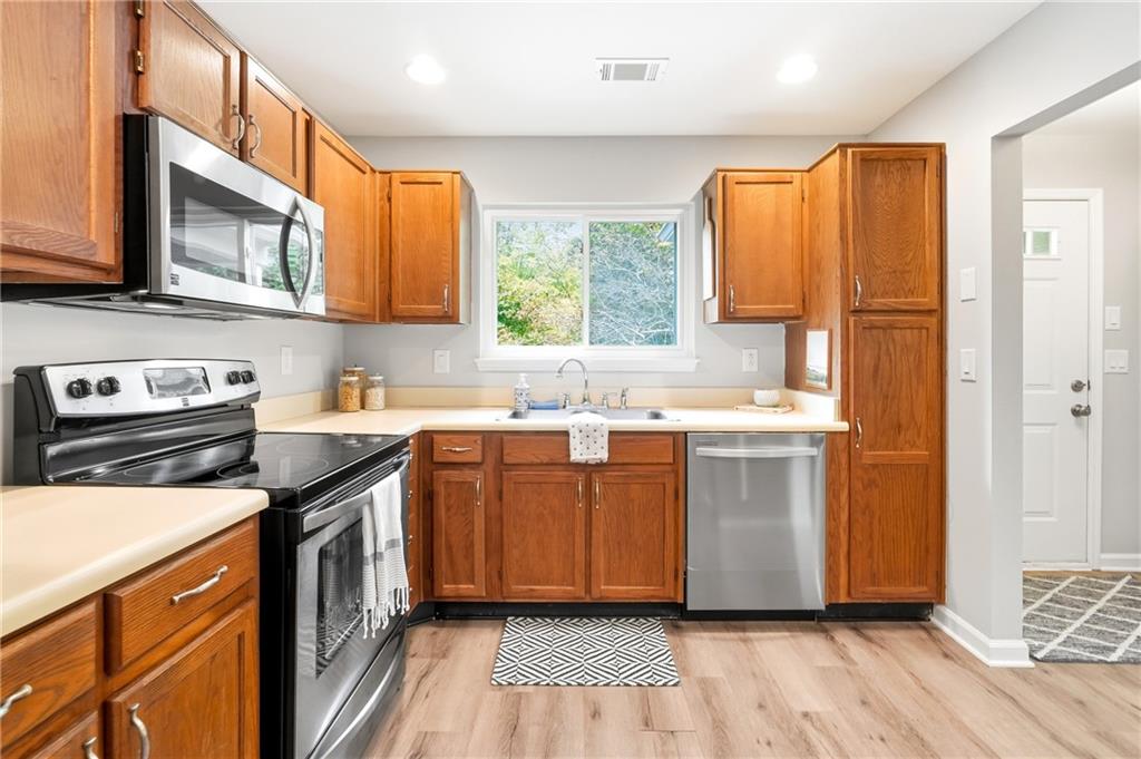604 Mill Pond Road, Unit 604 Roswell, GA 30076 - Photo 10 of 28 a kitchen with stainless steel appliances granite countertop a sink a stove a refrigerator cabinets and a window